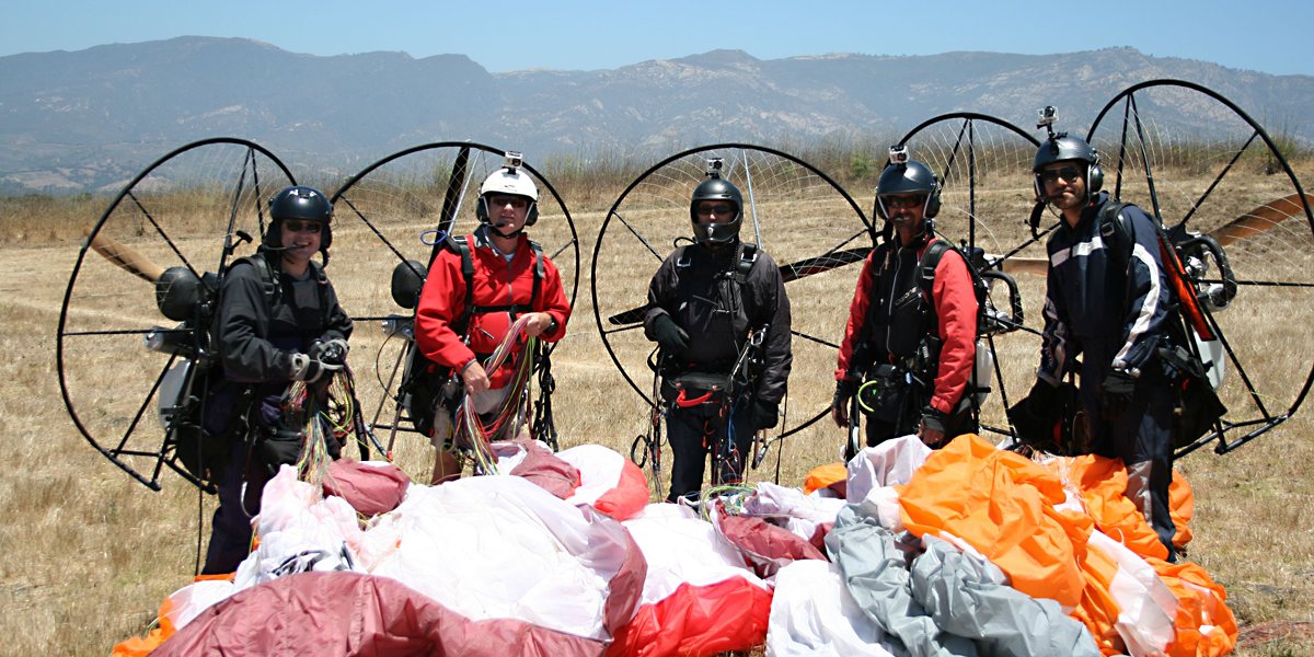 Five paramotorists standing side by side.