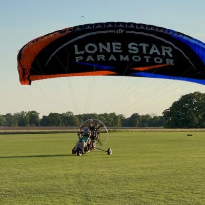 Paramotor trike taking off from the field