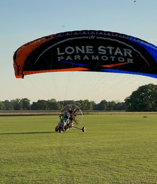 Paramotor trike taking off from the field