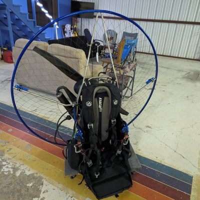 A paramotor with a blue fan cage