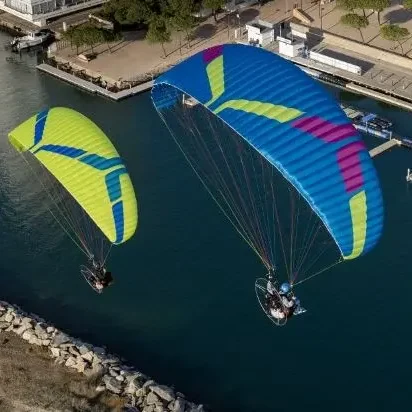 Aerial image of a pair of Ozone Kona 3 paramotor wings in flight