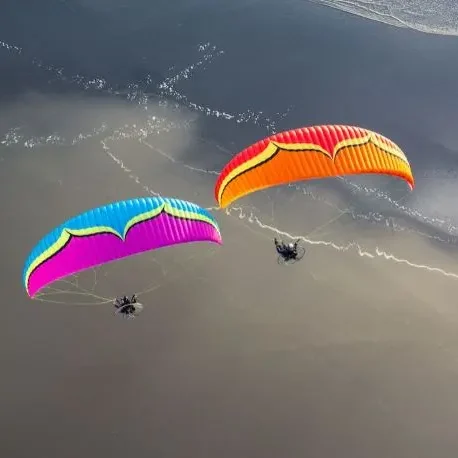 A pair of Ozone Roadster 3 paramotor wings in flight.
