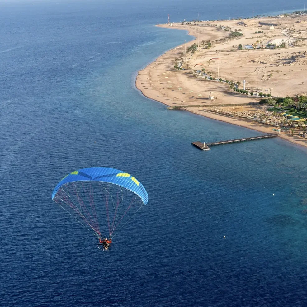 Aerial image of a Ozone Sirocco 3 paramotor wing in flight.