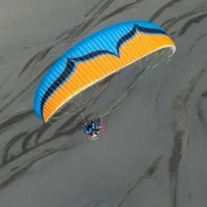 Aerial image of an Ozone Sypder 3 paramotor wing in flight.